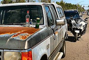Along S.E. 82nd Avenue of Roses, just after the return of Portland Police Bureaus Traffic Division, a drunk driver who also had arrest warrants was stopped and arrested. The open bottles and cans of the mini-bar he had in his vehicle are set out on the hood.