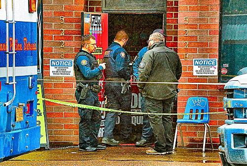 Officers conferred with a criminalist at the entrance of the store where the deadly shooting took place, in the Foster-Powell neighborhood.