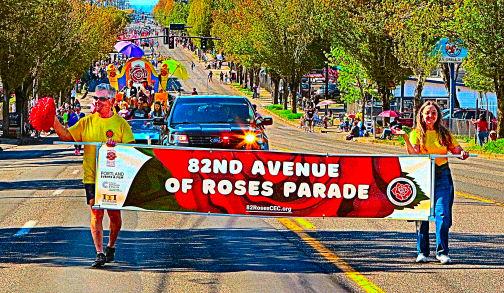 Here comes the 17th Annual 82nd Avenue of Roses Parade! Carrying the banner are volunteers Larry Smith and Kathryn Notson.