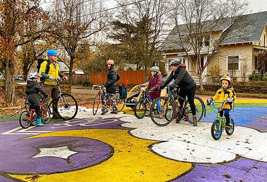 Students and parents gather at the starting point of Creston School�s new bike bus, atop the rainbow mural at S.E. Center Street and 60th Avenue. The group then rides together to the school, making two stops along the way, to collect more riders.