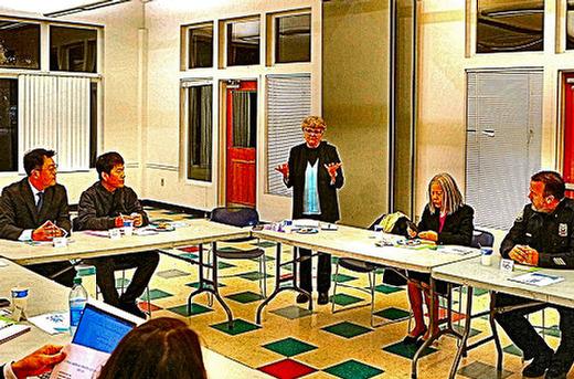 BDNA Chair Stephenie Frederick (standing, center) welcomed participants to the December roundtable, convened to help Korean-owned convenience store operators in that neighborhood to be more resilient to crime and vandalism.