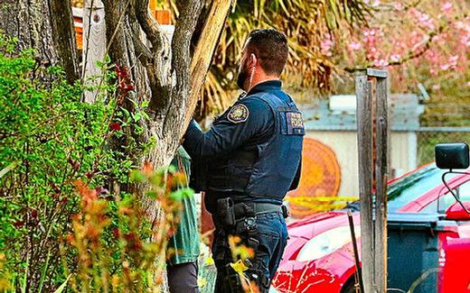 A Central Precinct officer spoke with a neighbor, as the police search for the stabbing suspect in the Brooklyn neighborhood continued.