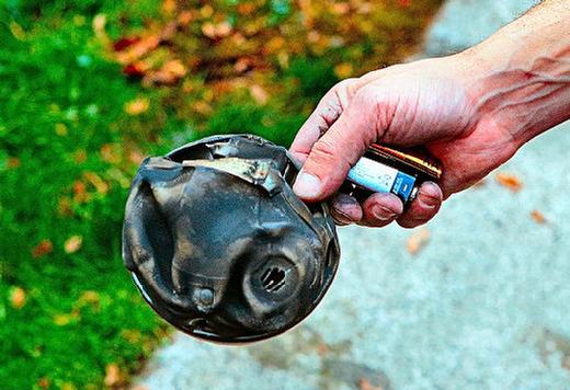 A firefighter shows the battered and partly-melted smoke alarm that was still screaming a warning until he took the batteries out.