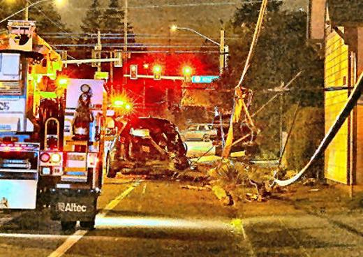 Heres a look through a telephoto lens along S.E. Woodstock Boulevard -- where cables and wires were sagging after a wooden utility pole was been snapped in two by a tow-truck