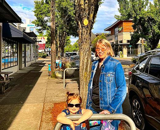 Sherry Hall, shown here with her granddaughter Juniper, helped plant these trees � in the very first Friends of Trees community tree planting in the city. It was here, on Woodstock Boulevard. In 1989, that she and Terry Griffiths organized the planting of 21 trees. Now, Portland has just discarded its longtime partnership with the local tree-planting nonprofit.